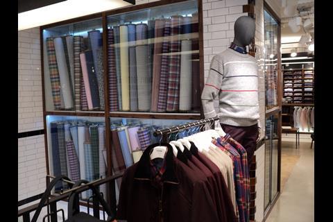 A floor to ceiling glass display cabinet filled with rolls of cloth is a standout feature and brings to mind a tailor’s stockroom. Side-hung stock is also placed on rails along the window line